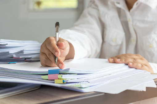 A hand writing on a stack of paper
